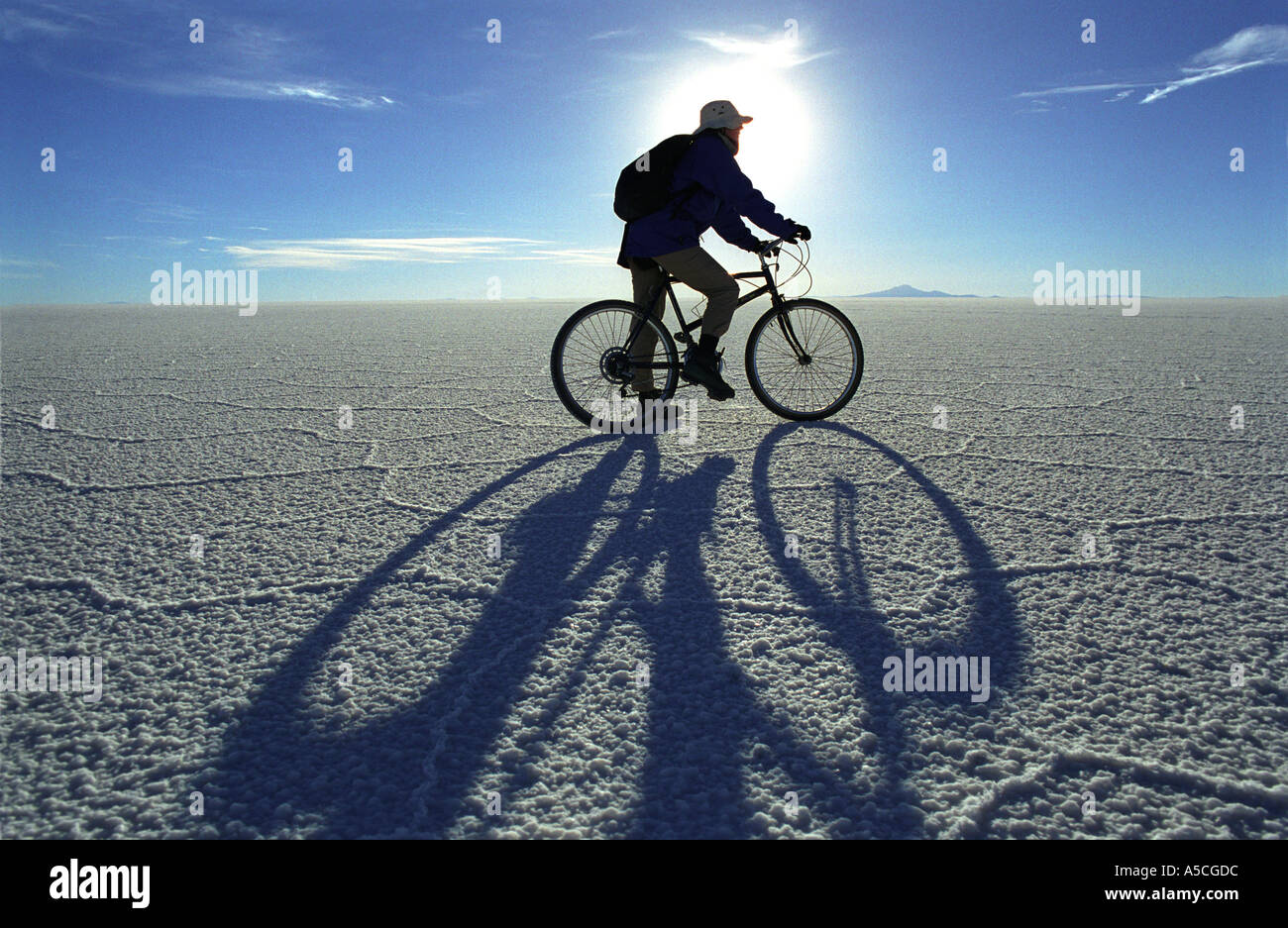 A female cyclist on a bike on the Salar de Uyuni Bolivia largest salt pan plain in the world Stock Photo