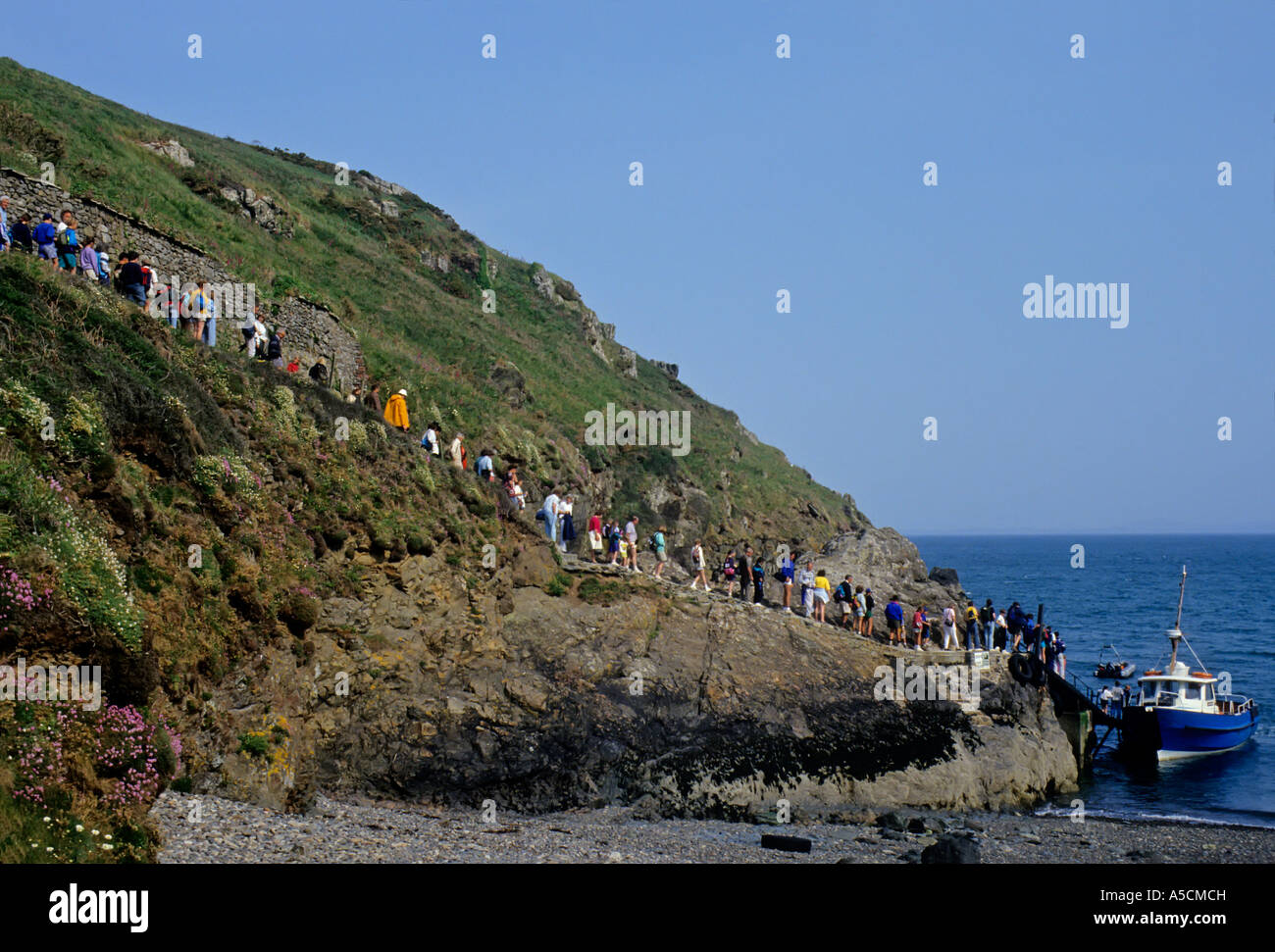 Line of people waiting to board the nature watching boat to Skomer island Martin s Haven Wales UK Stock Photo
