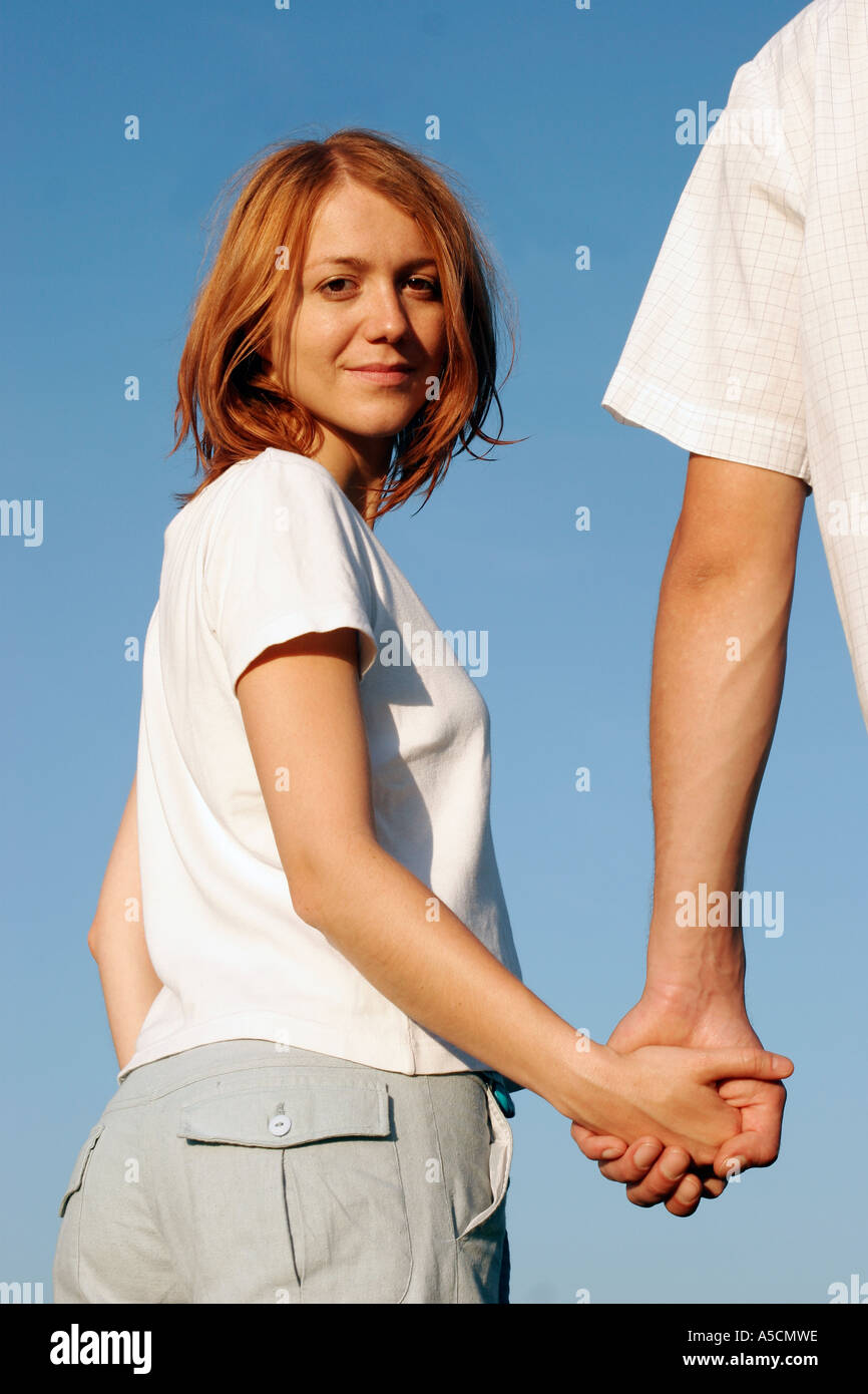 Young couple holding hands outdoors, smiling Stock Photo Alamy