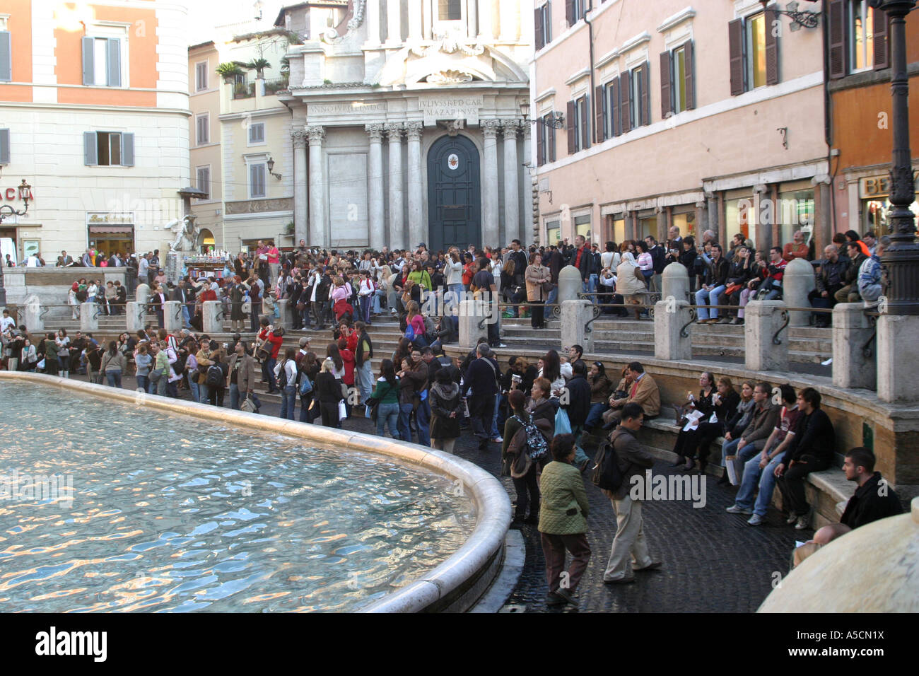 crowds throng to throw the traditional coin in the famous Trevi