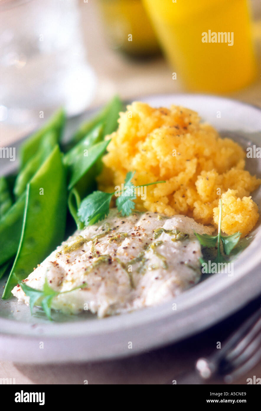 Poached fish with lime shreds and mixed ground pepper with mangetout peas and mashed swede Garnished with coriander Stock Photo