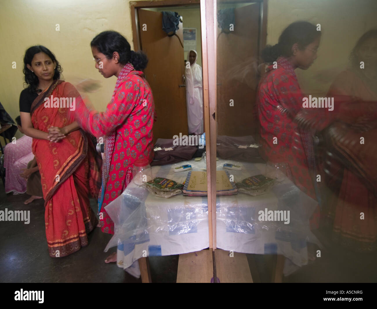 Women garment workers meet with their supervisor to get work they will do at home Stock Photo