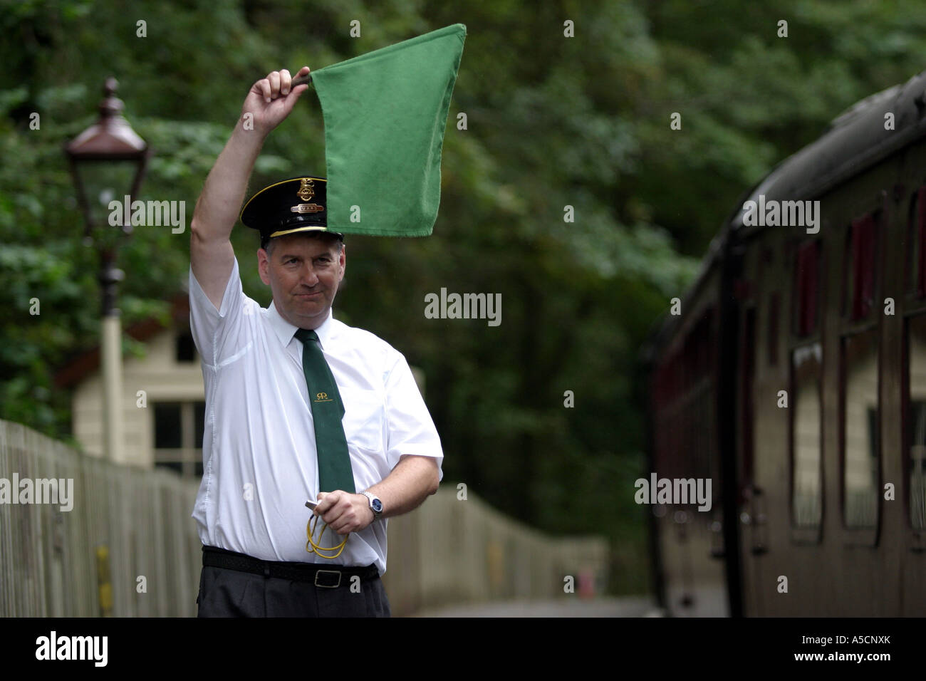 30th August 2006. The train guard raises his green flag to tell the