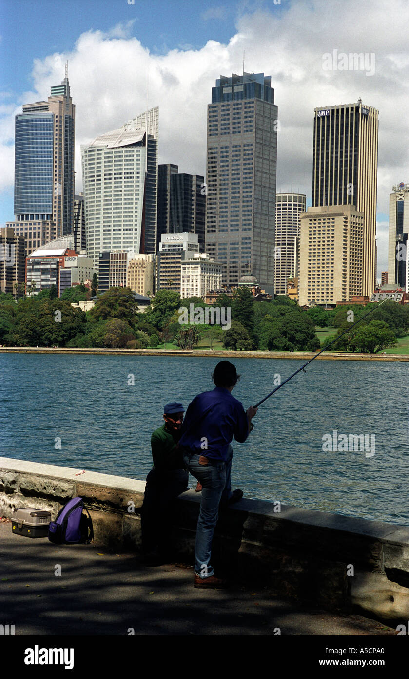 Australia the Sydney skyline is the backdrop for anglers by the harbour in the Royal Botanic gardens Stock Photo
