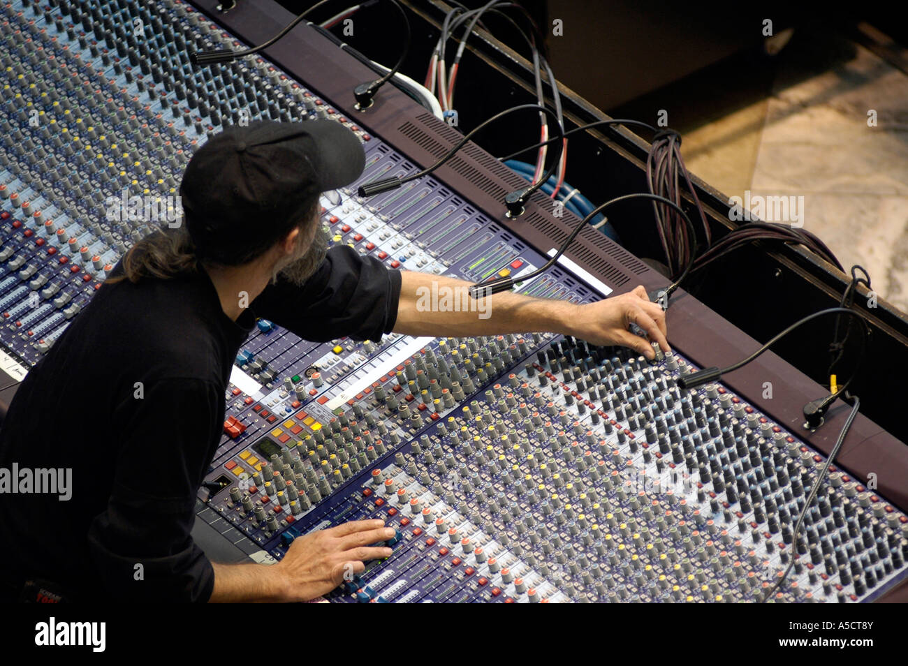 A sound technician adjusts a sound board during a performance Stock