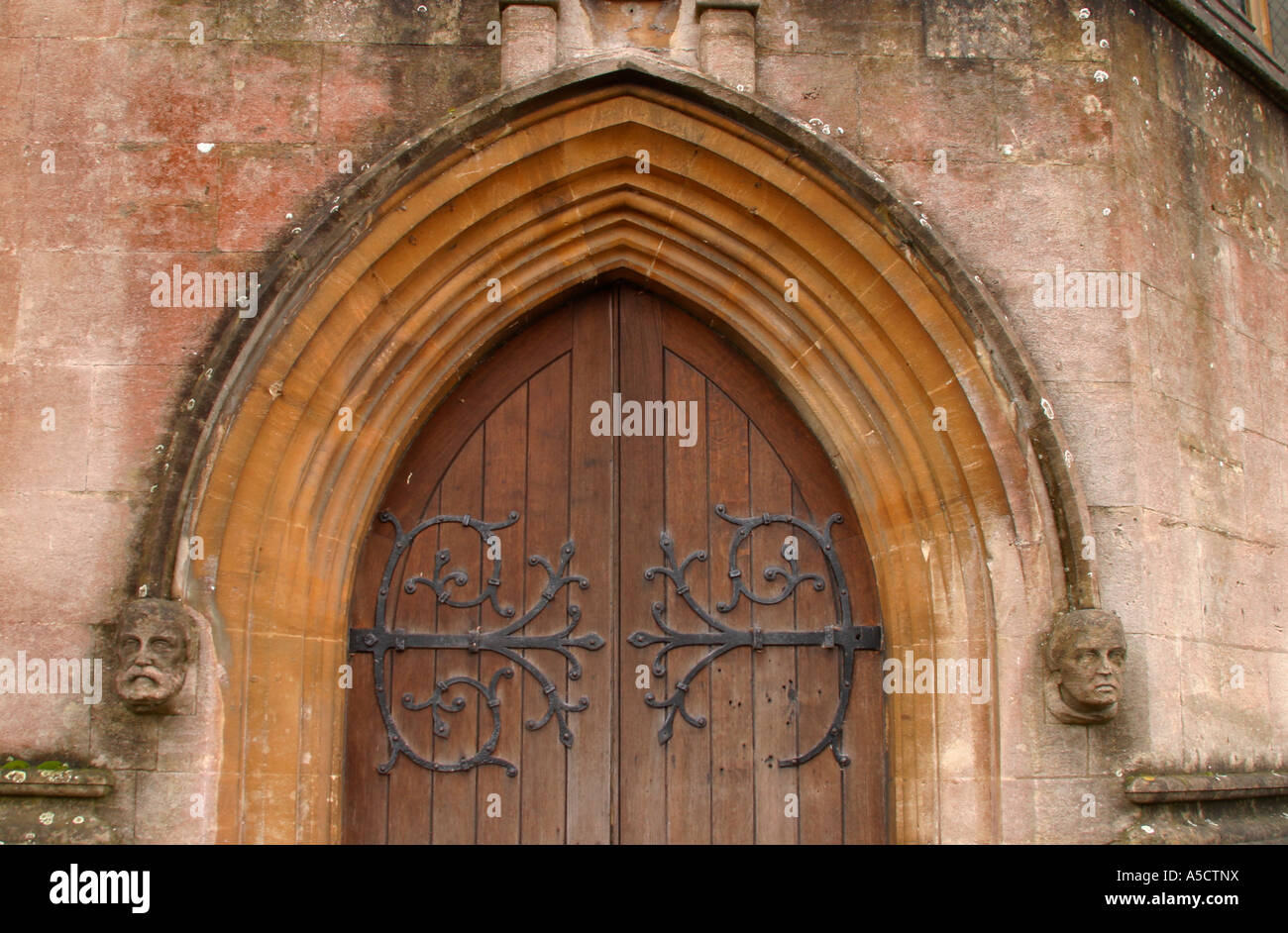Sculptured heads either side of wooden door at Arundel Cathedral, West Sussex, england Stock Photo