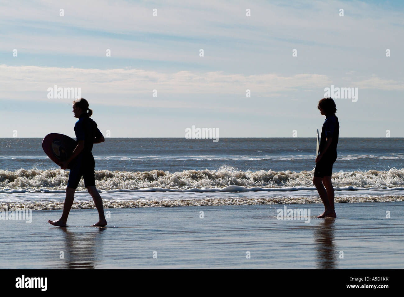 Teen boys with skimboard on the beach Stock Photo Alamy