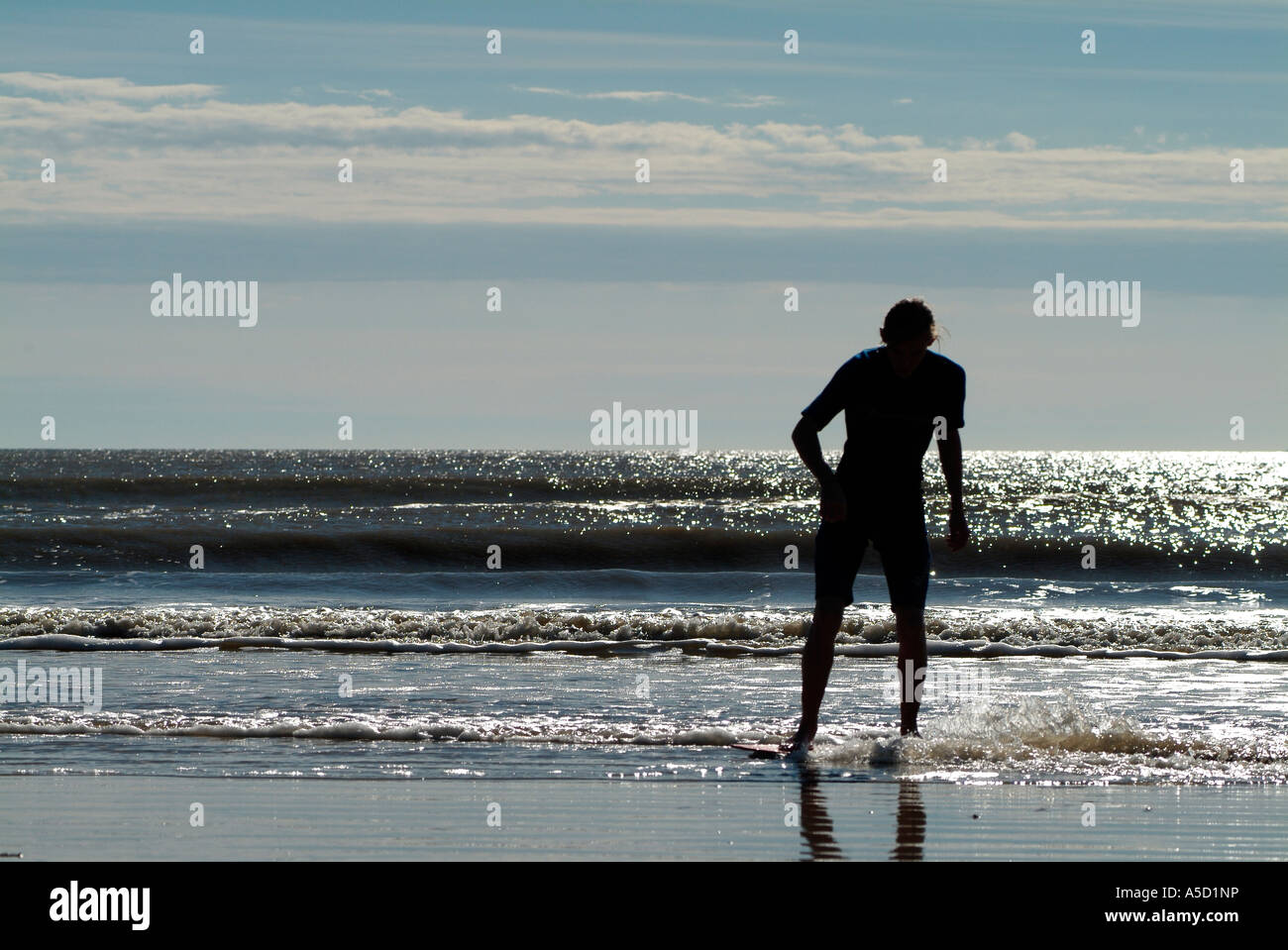 Teen boy with skimboard on the beach Stock Photo