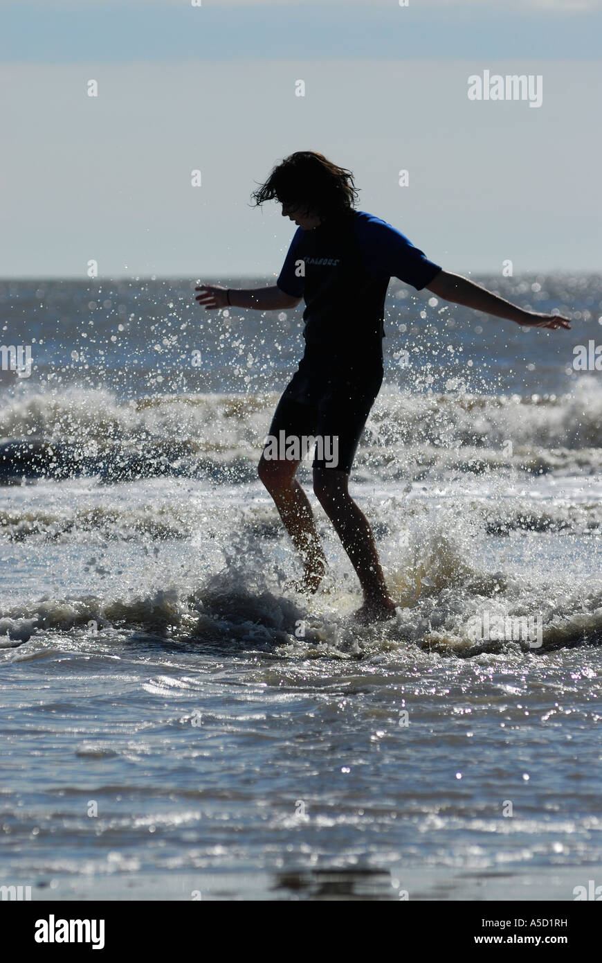 Teen boy with skimboard on the beach Stock Photo