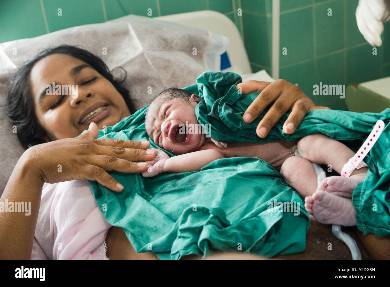 Mother is holding her new born baby in San Fernando Maternity Hospital in San  Fernando, Trinidad, The Caribbean Stock Photo