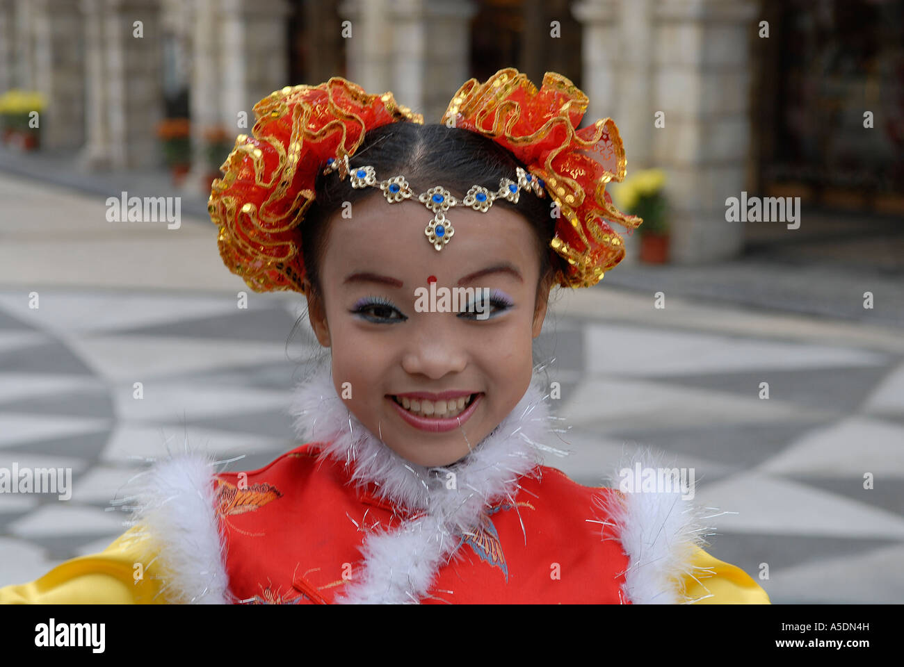 Young girl in traditional clothing smiles during Chinese New Year celebrations in Macao China