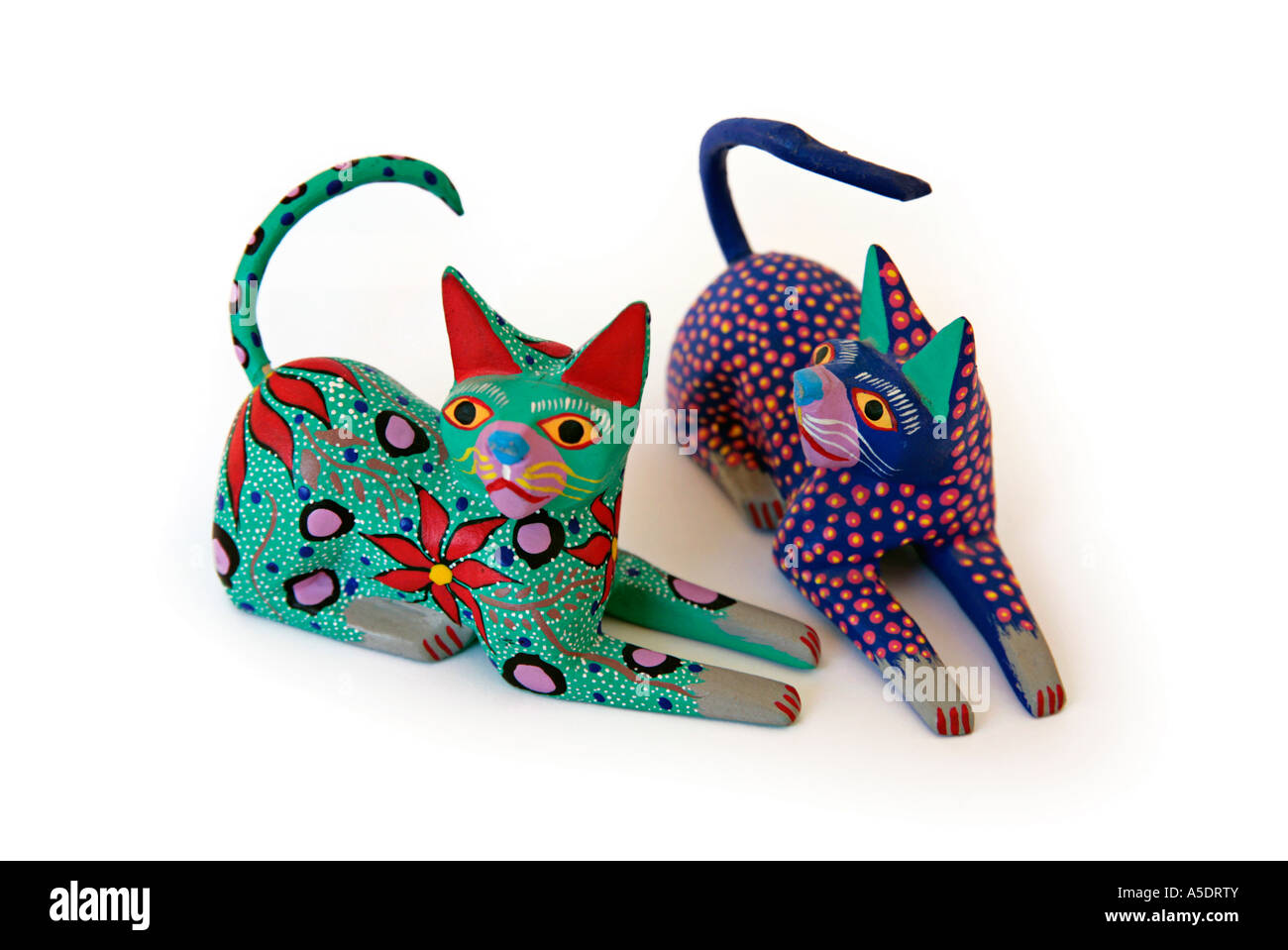Mexican carved wooden painted cats shown as a cut-out Stock Photo