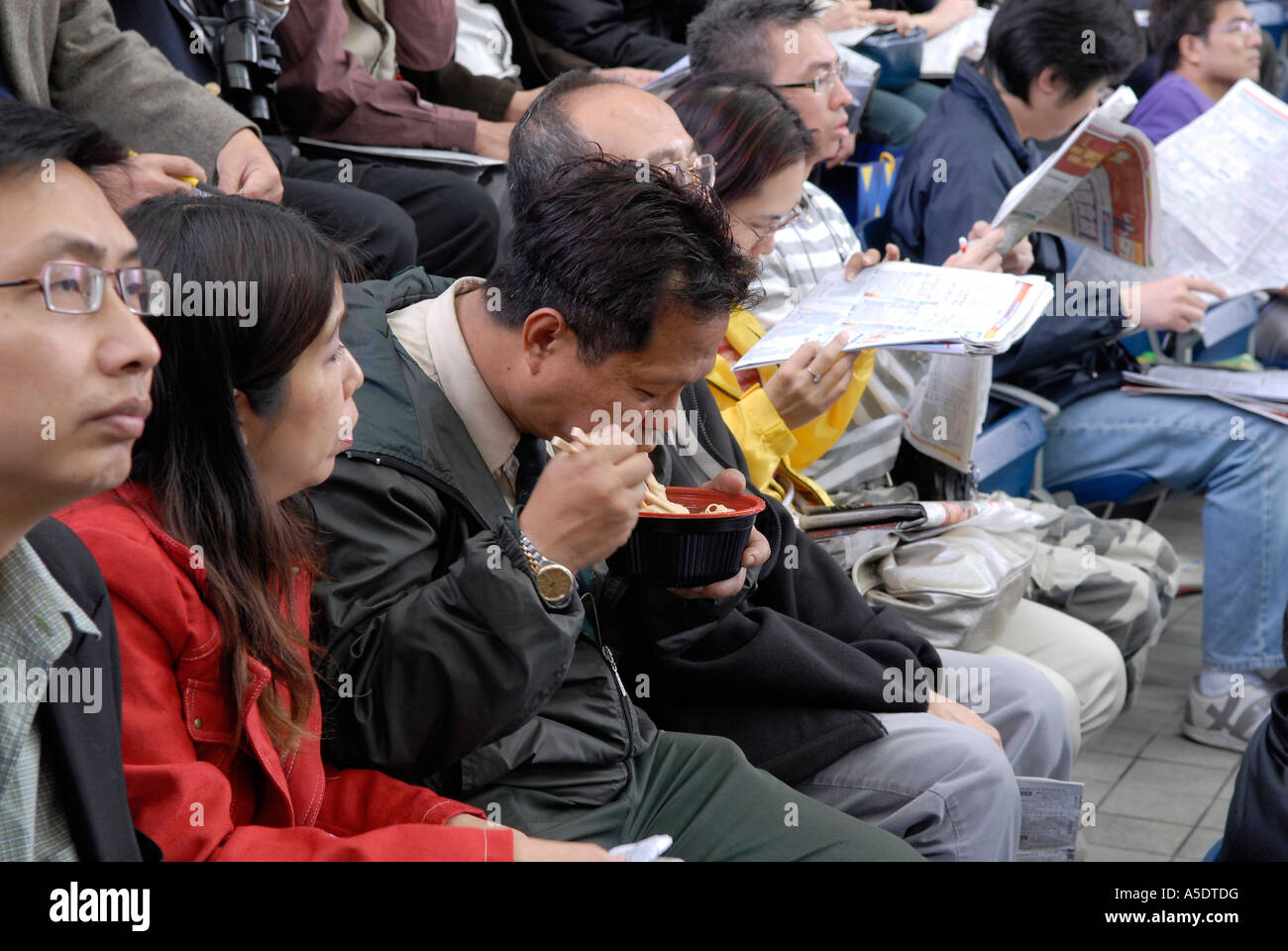 Spectator eating noddle at Sha Tin Racecourse in the New Territories Hong Kong china Stock Photo