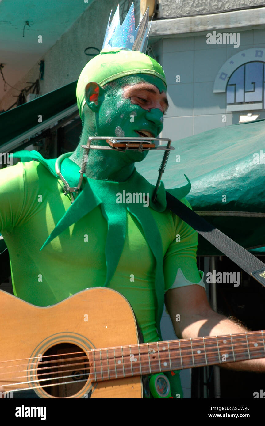 A male adult with green body paint guitar and mouth organ Stock Photo -  Alamy