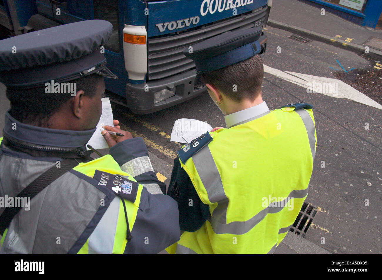 Traffic warden attendant writing out a ticket in London England Stock Photo