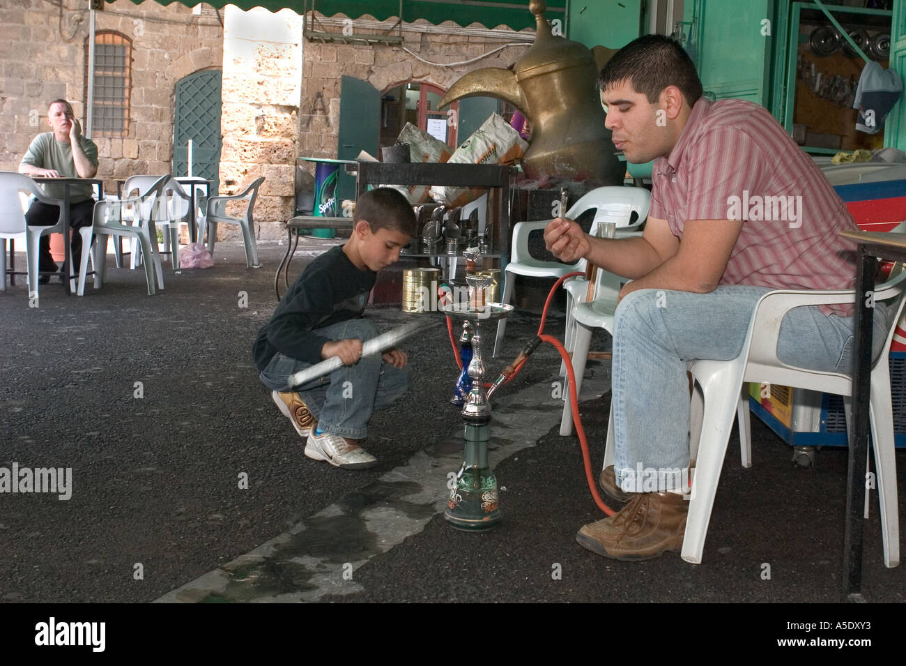 Lighting and smoking a nargila an Arab water pipe Stock Photo