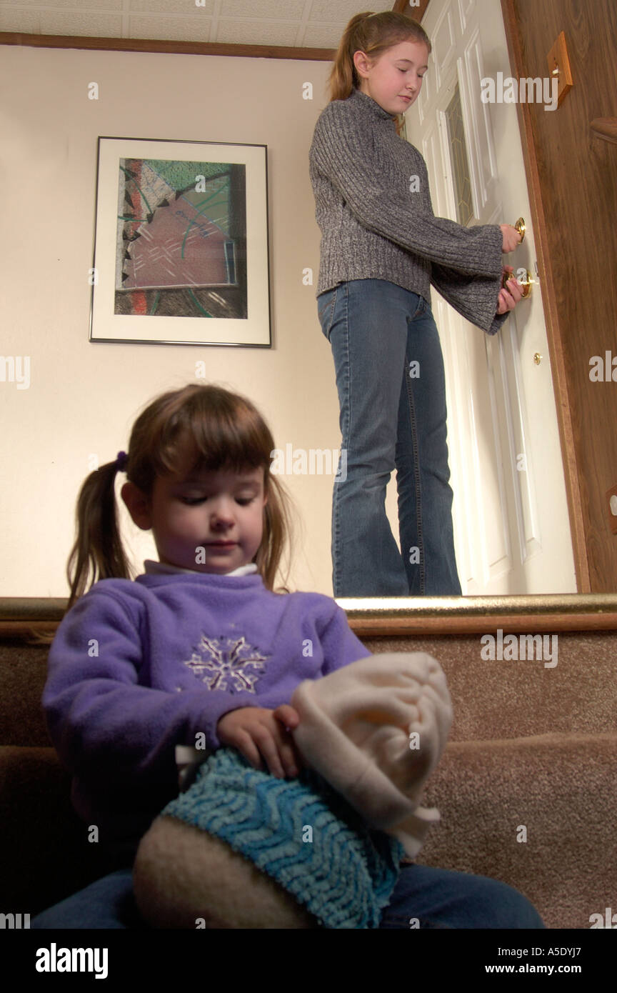 Babysitter Checking Door Lock, Child in FG Stock Photo Alamy