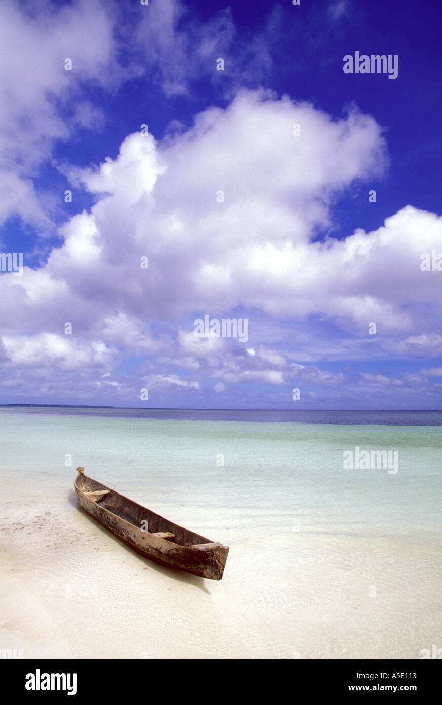 Dugout canoe on white sand beach in the Mallucu Islands of eastern Indonesia Stock Photo
