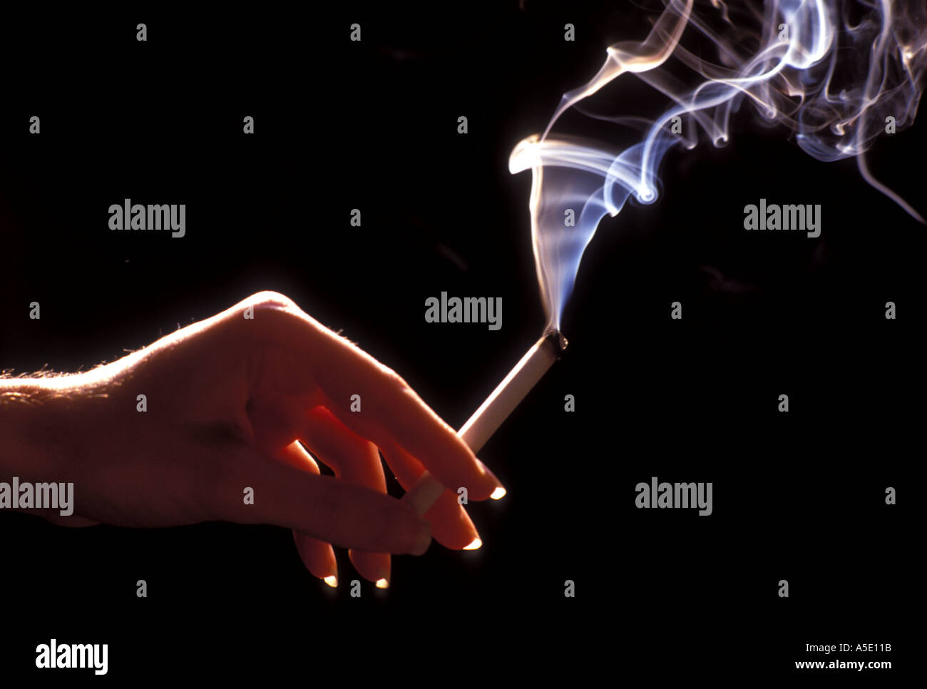 Womans hand holding burning cigarette Stock Photo Alamy