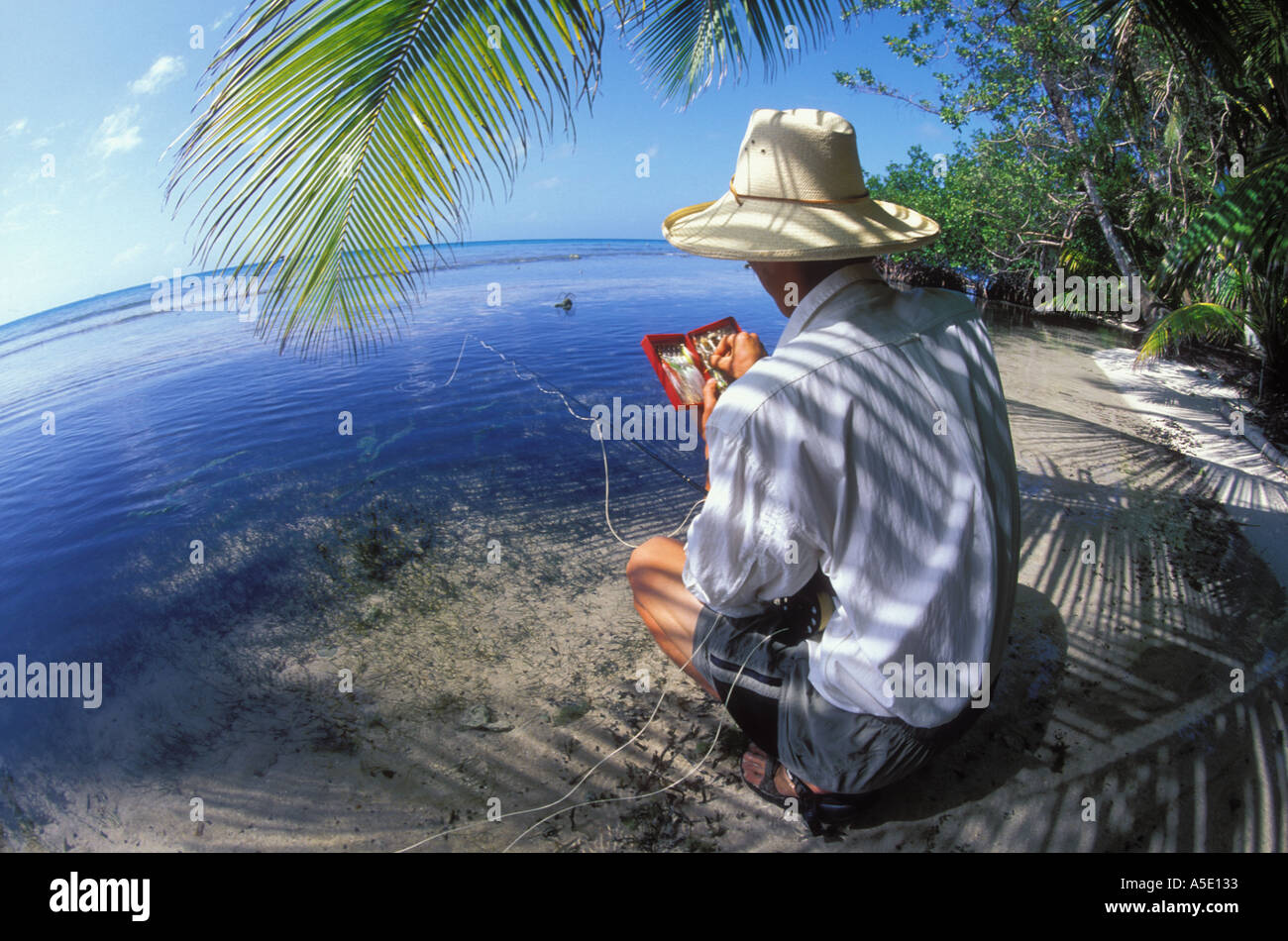 Fly fisherman selecting the right fly in Belize Central America Caribbean Stock Photo