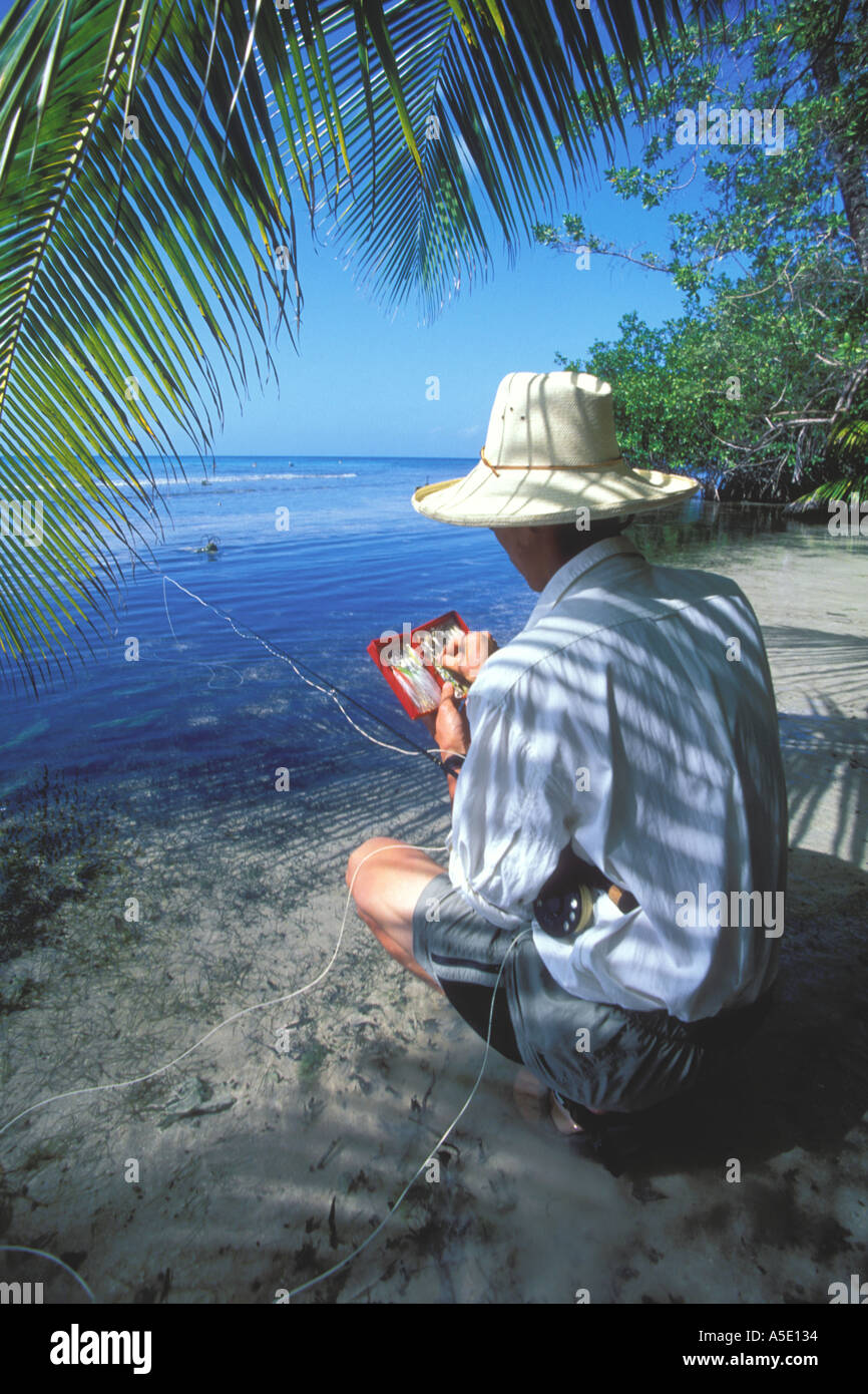 Fly fisherman selecting the right fly in Belize Central America Caribbean Stock Photo