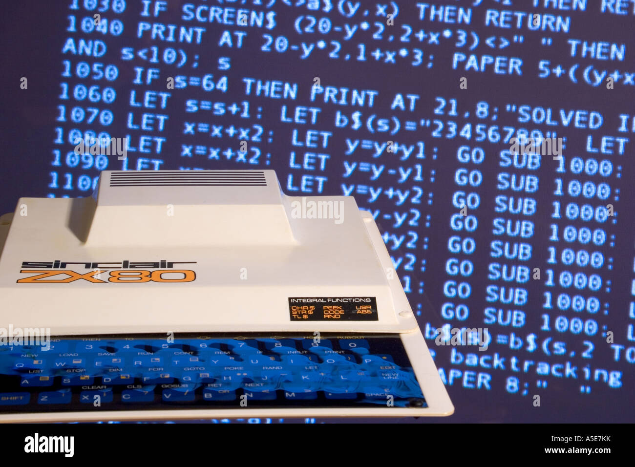 Sinclair ZX80 home computer against tv screen displaying BASIC programming language code Stock Photo