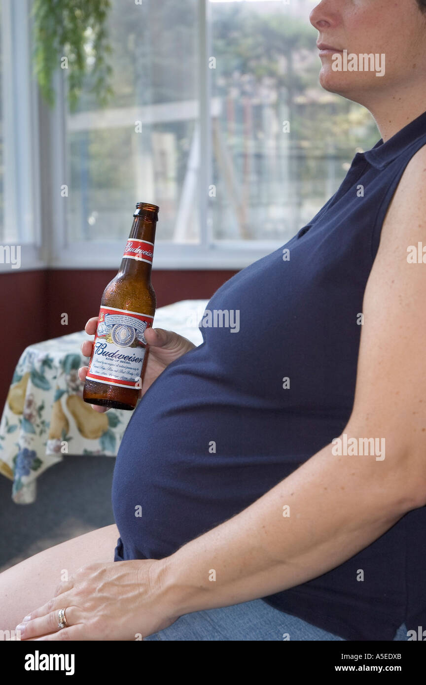 Close up of pregnant caucasian woman holding a beer Stock Photo