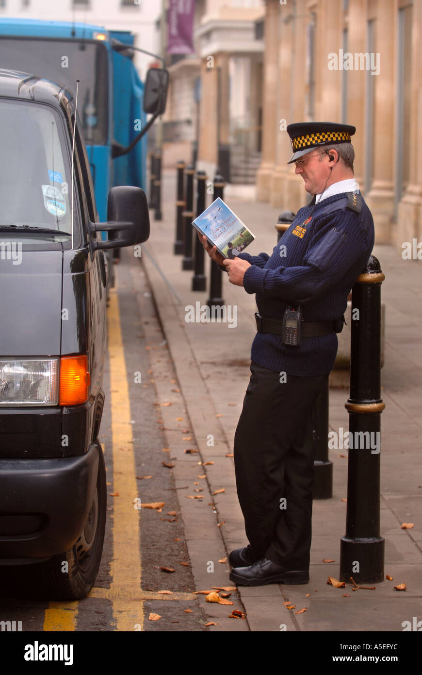 AN OFF DUTY TRAFFIC WARDEN READING AS PART OF THE BOOK DROP SCHEME AT THE CHELTENHAM LITERARY FESTIVAL UK Stock Photo