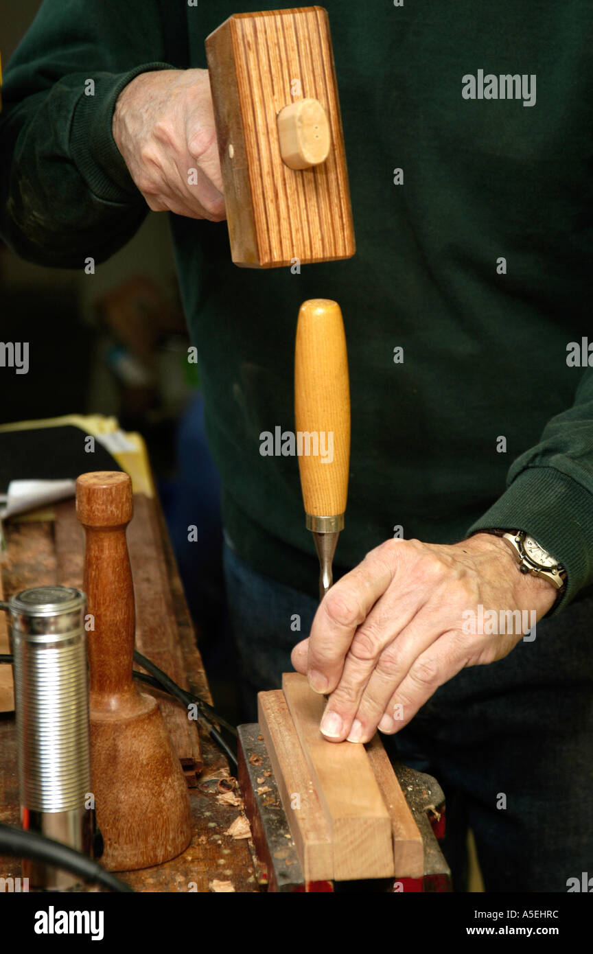 P12 118 Woodworker uses wooden hammer to knock out excess wood 2 Stock Photo