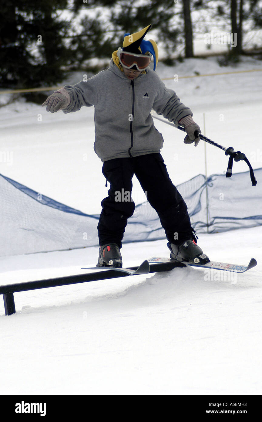 Mixedrace 13 yearold boy wearing goggles skids sideways on rail