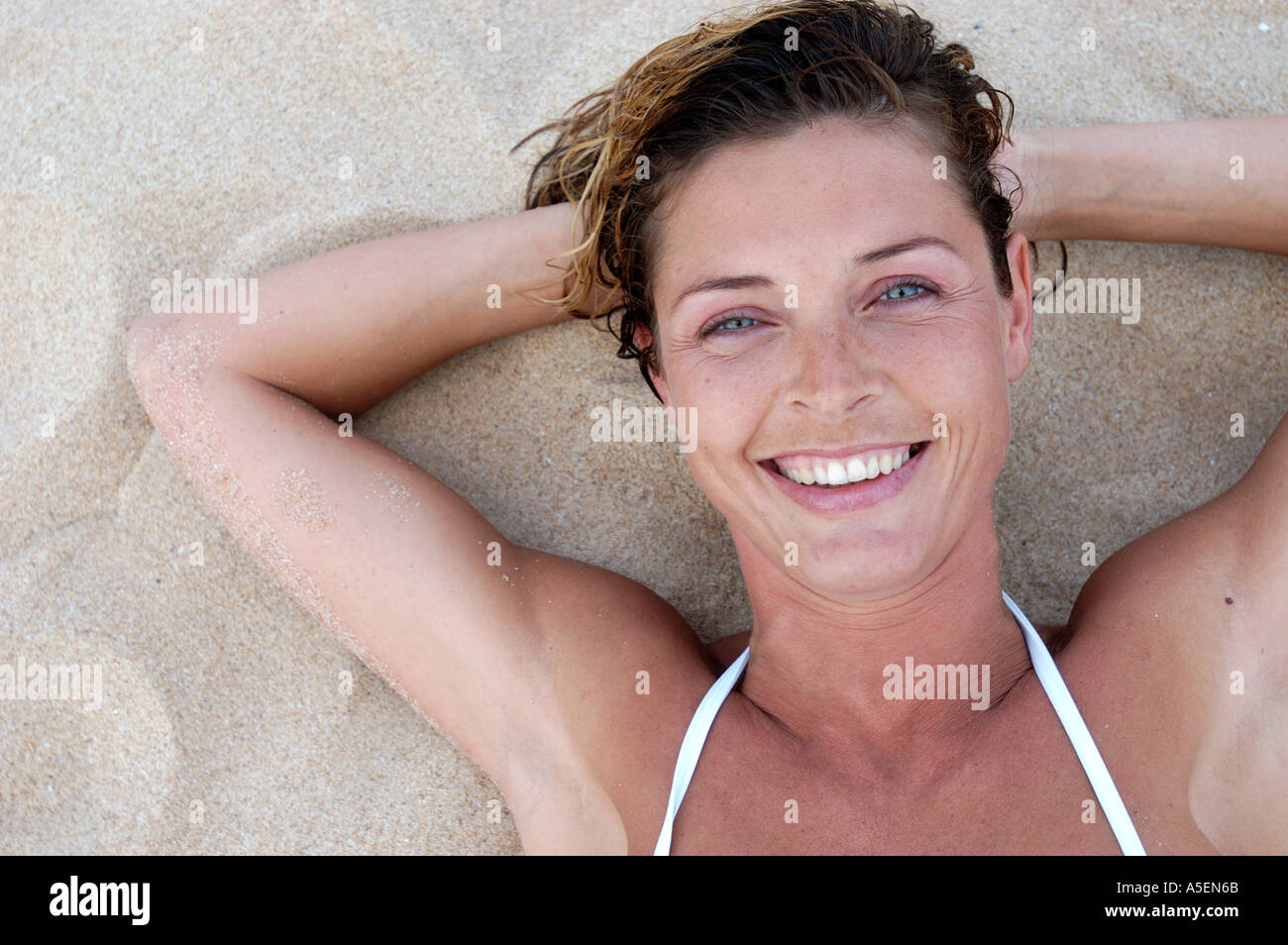 face woman sunbathing woman laying on sand Stock Photo Alamy