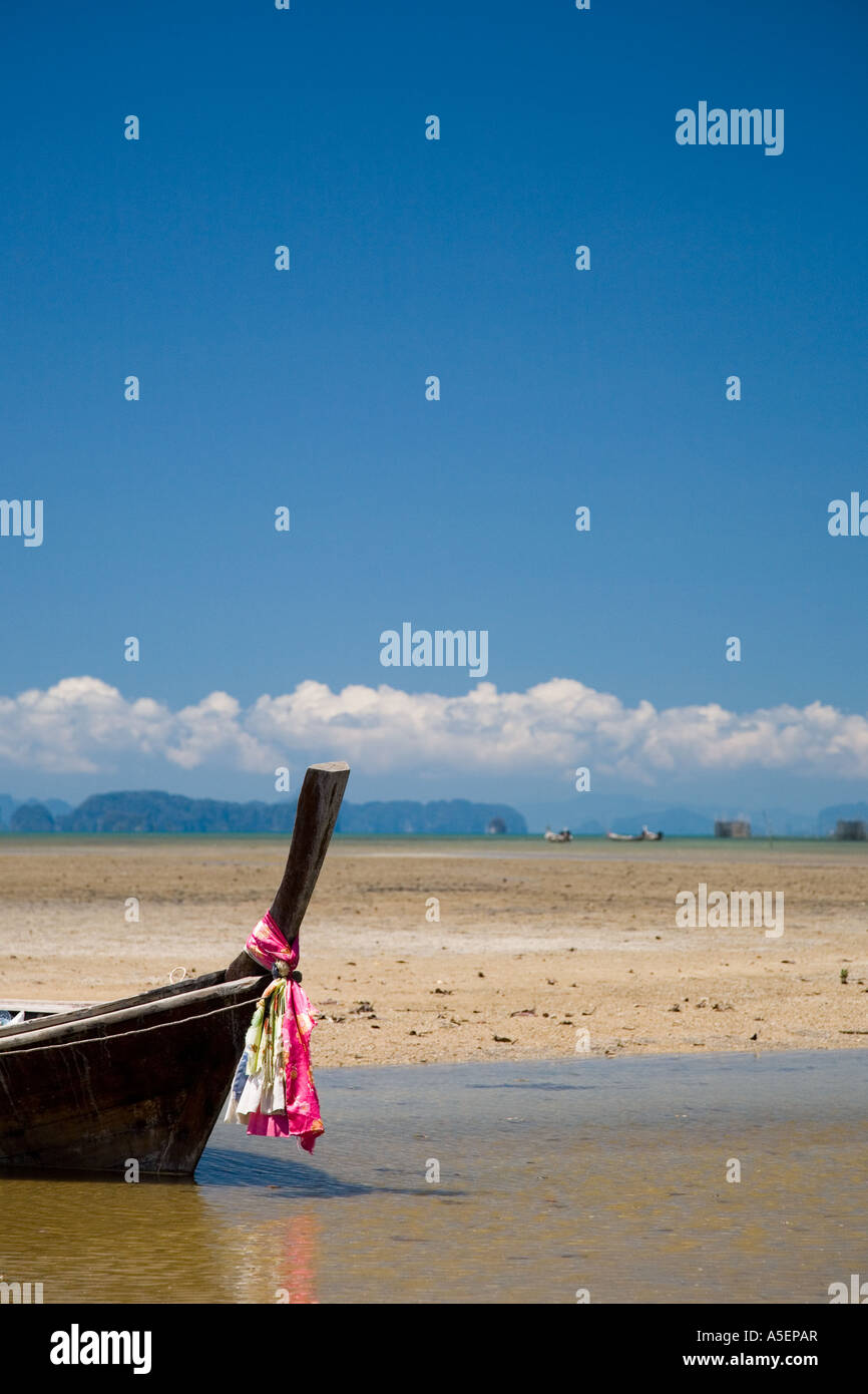 Long-tailed boat beached in inlet  Khaotong Bay Krabi Province southern Thailand Stock Photo