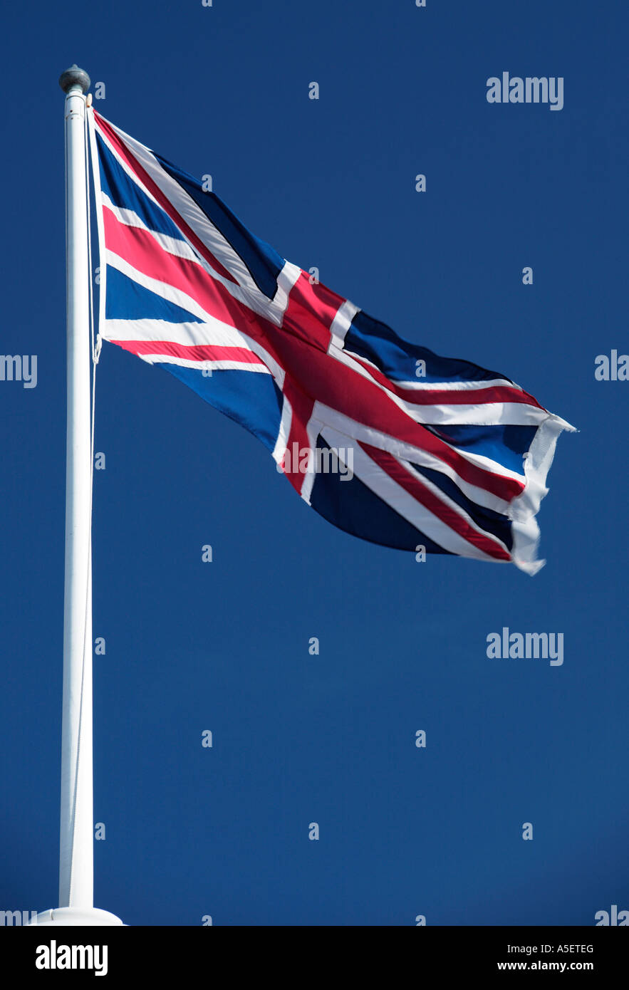 Union Jack Flag flying against blue sky Stock Photo - Alamy