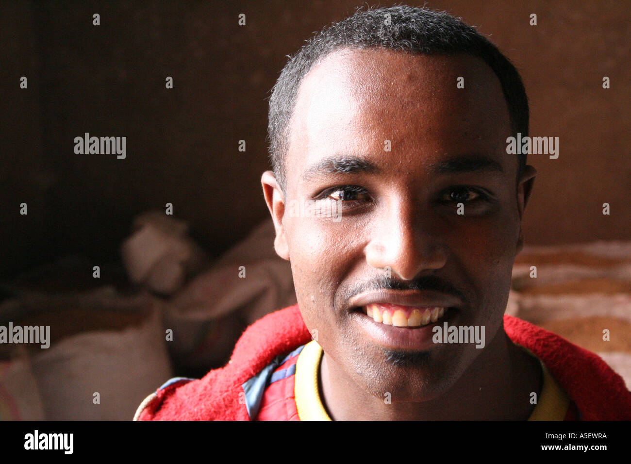 Attractive smiling young black man in a grain milling factory, Harar, Ethiopia Stock Photo