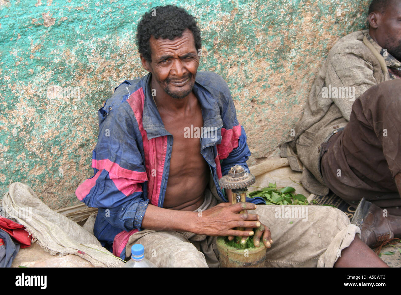 Harar, Ethiopia, Homless Qat addict crushes the leaves because his teeth have fallen out. Stock Photo