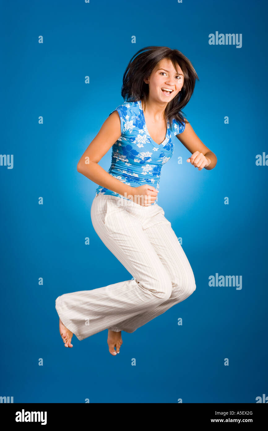 jumping happy woman on the blue background Stock Photo - Alamy