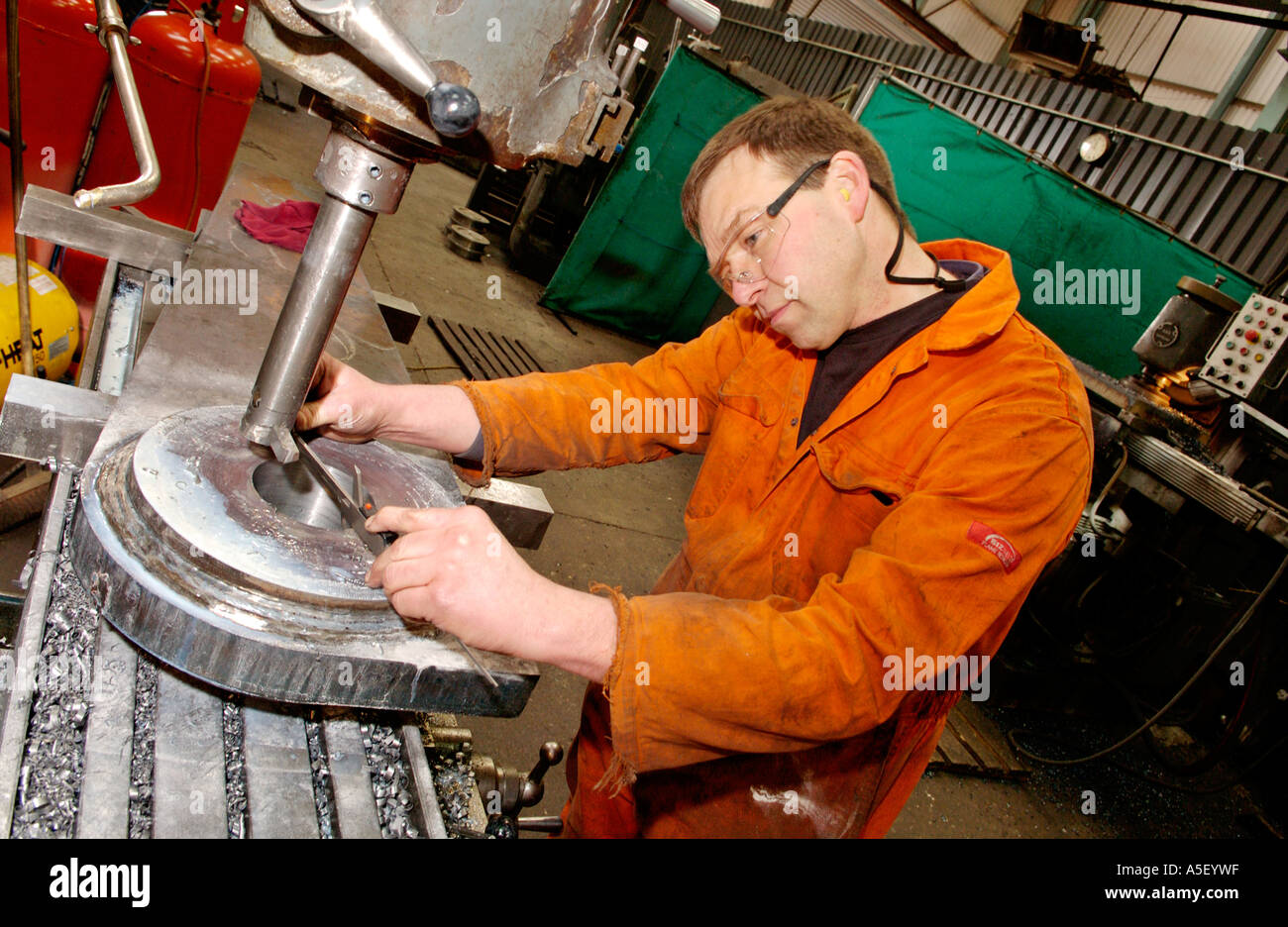 Engineer boring precision hole in steel fabrication UK Stock Photo