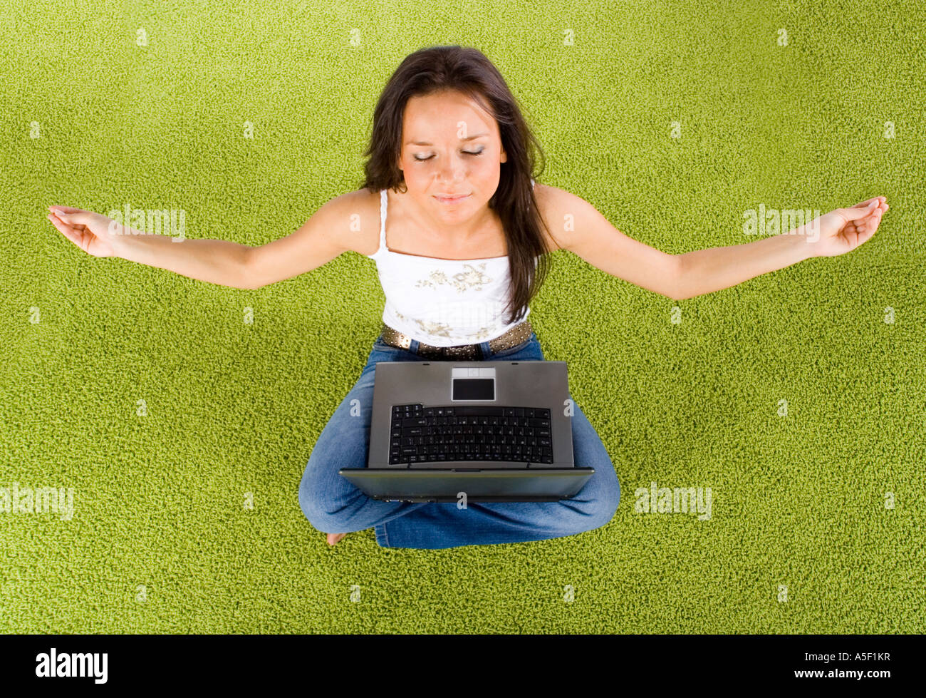 young woman with laptop relaxing on the green carpet Stock Photo - Alamy