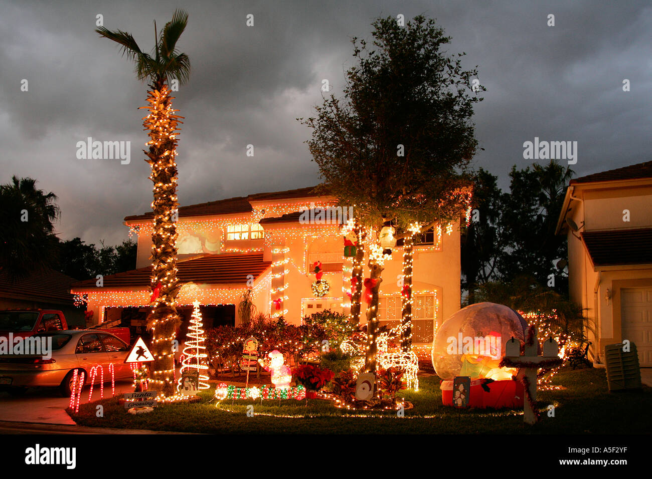 Christmas decorations front garden night time twinkling lights palm tree  hot weather tacky winter holiday tradition residential Stock Photo - Alamy