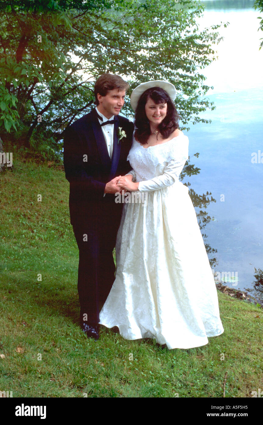 Bride and Groom holding hands by Roy Lake after wedding ceremony age 25