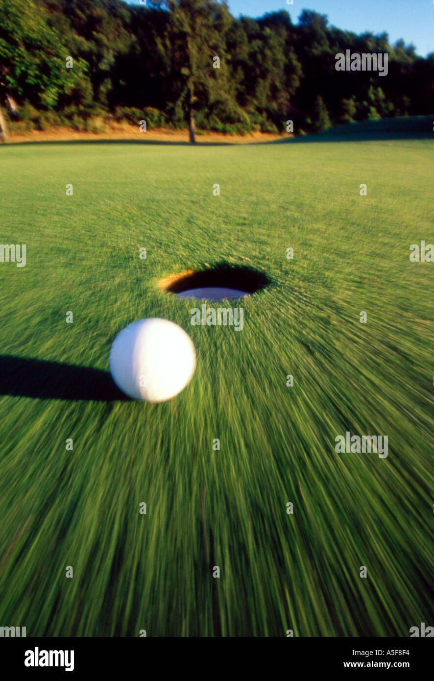 Golf ball rolling towards the hole Stock Photo Alamy