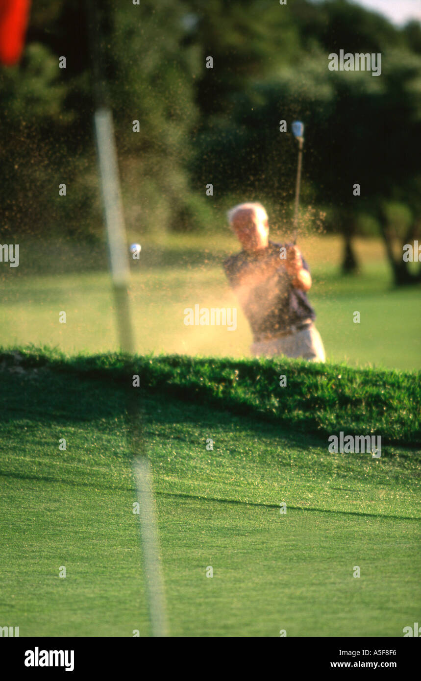 Golfer hitting a ball out of a sand trap Stock Photo Alamy