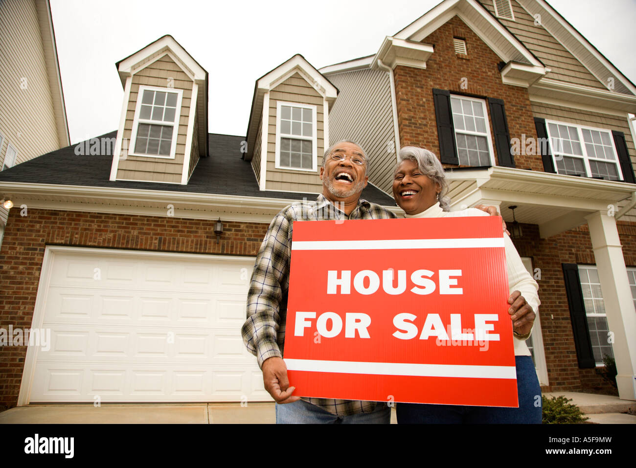 Portrait of middle aged African American couple outside house with for ...