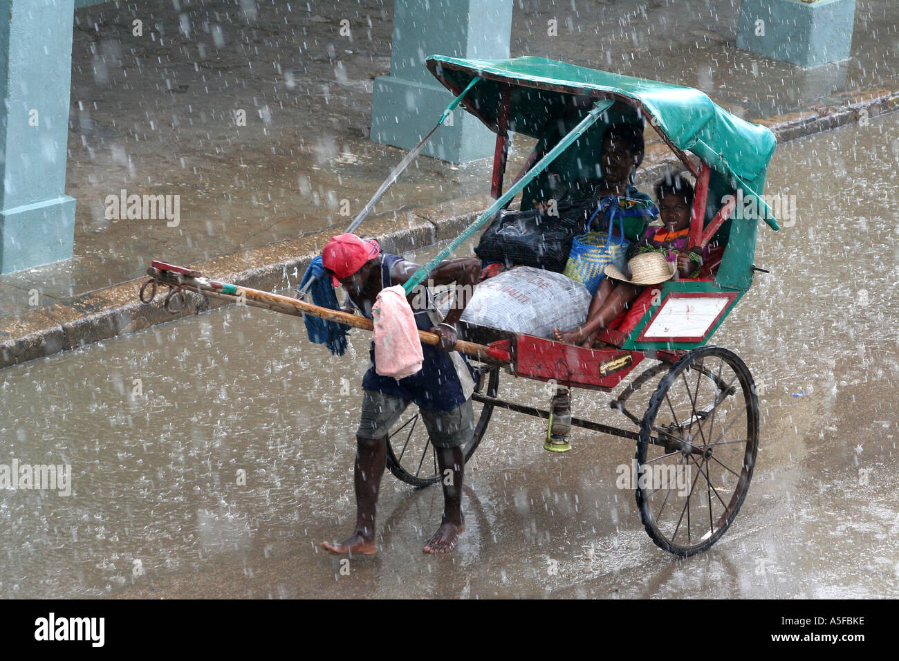 Madagascar, Pousse Pousse, peditaxi, driver pulling through a heavy rain, Toliara ( Tulear ) Stock Photo