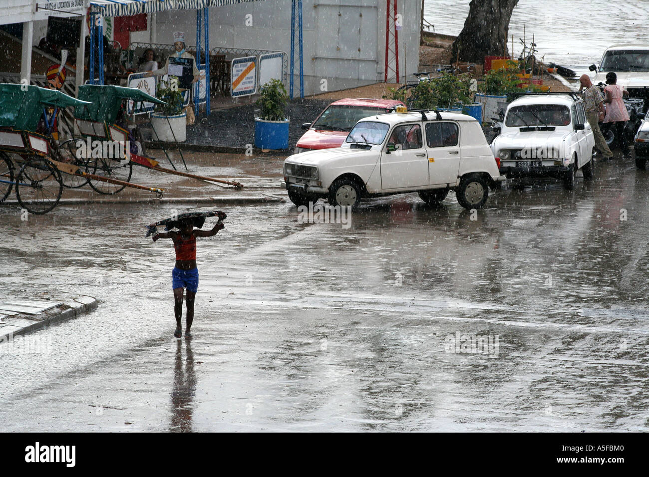 Madagascar, woman shields herself from a heavy rain, Toliara ( Tulear ) Stock Photo