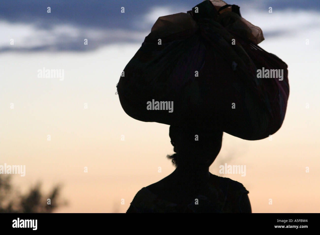 Silhouette of a woman carrying a large bag on her head in Ifaty, north of Toliara, ( Tulear ), Madagascar Stock Photo