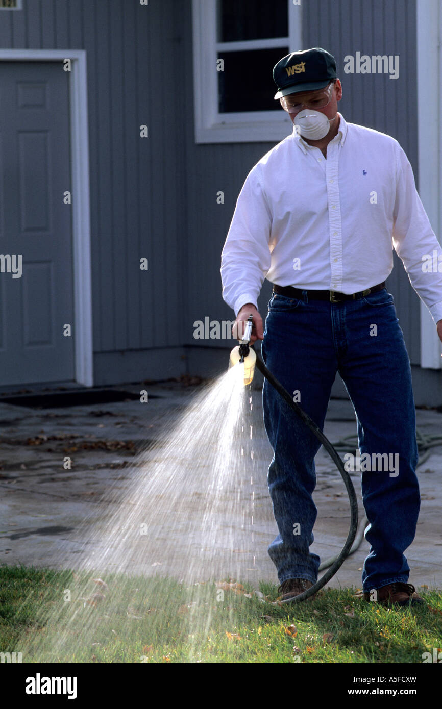 A man applying a chemical lawn treatment Stock Photo