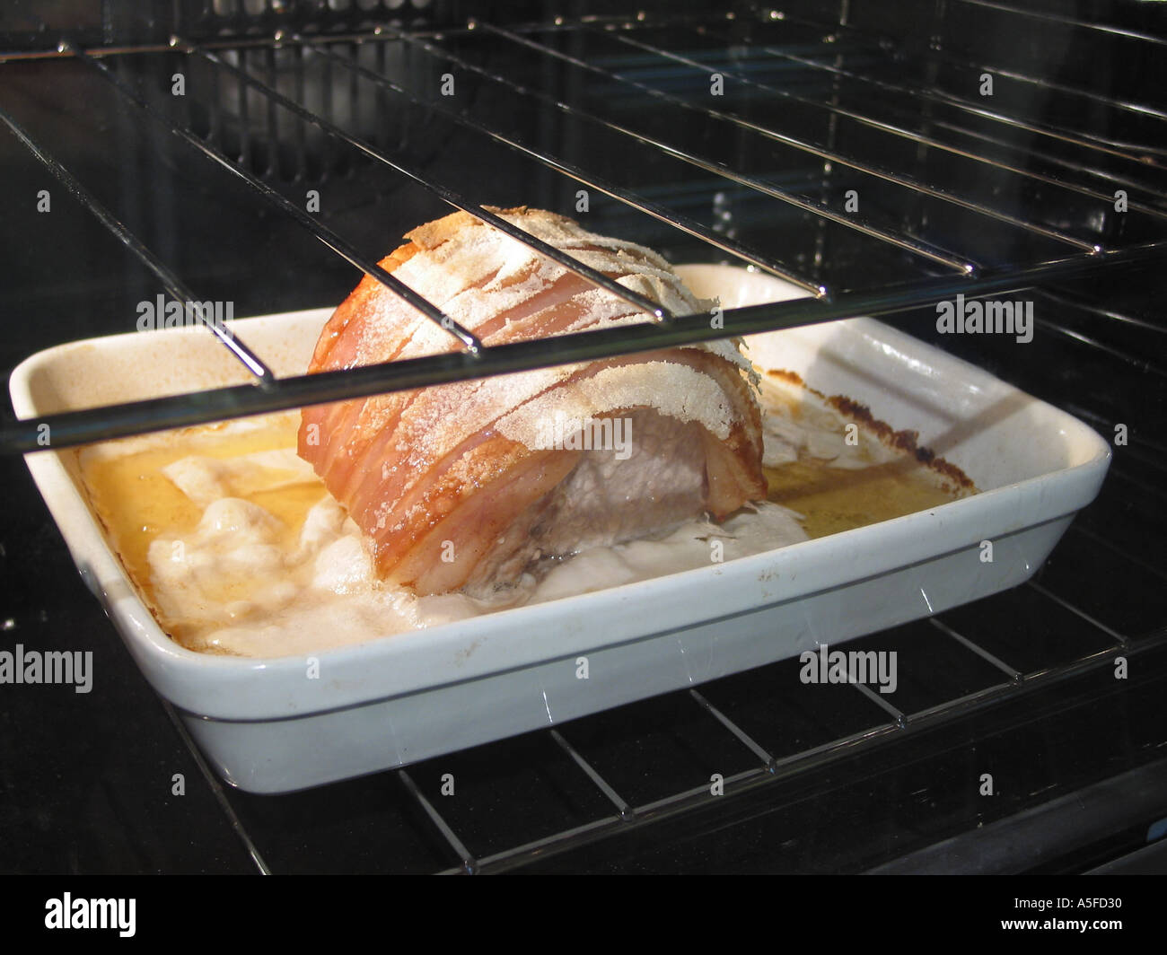 Roast Pork, cooking in oven Stock Photo