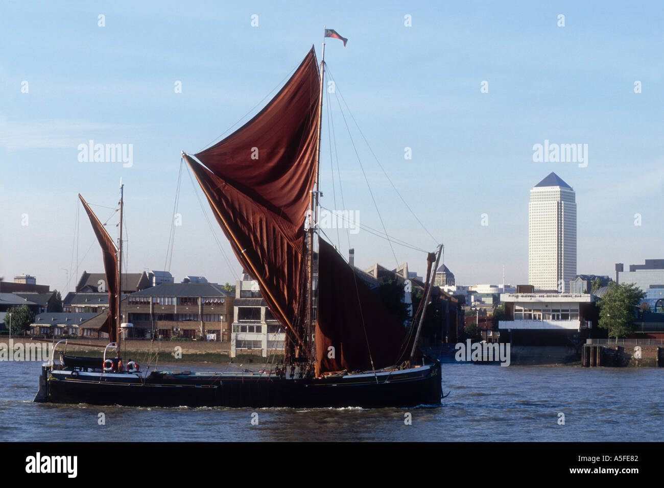 The 1895 Thames Sailing Barge Thistle on the River Thames at London England UK with 'Canary Wharf' Stock Photo