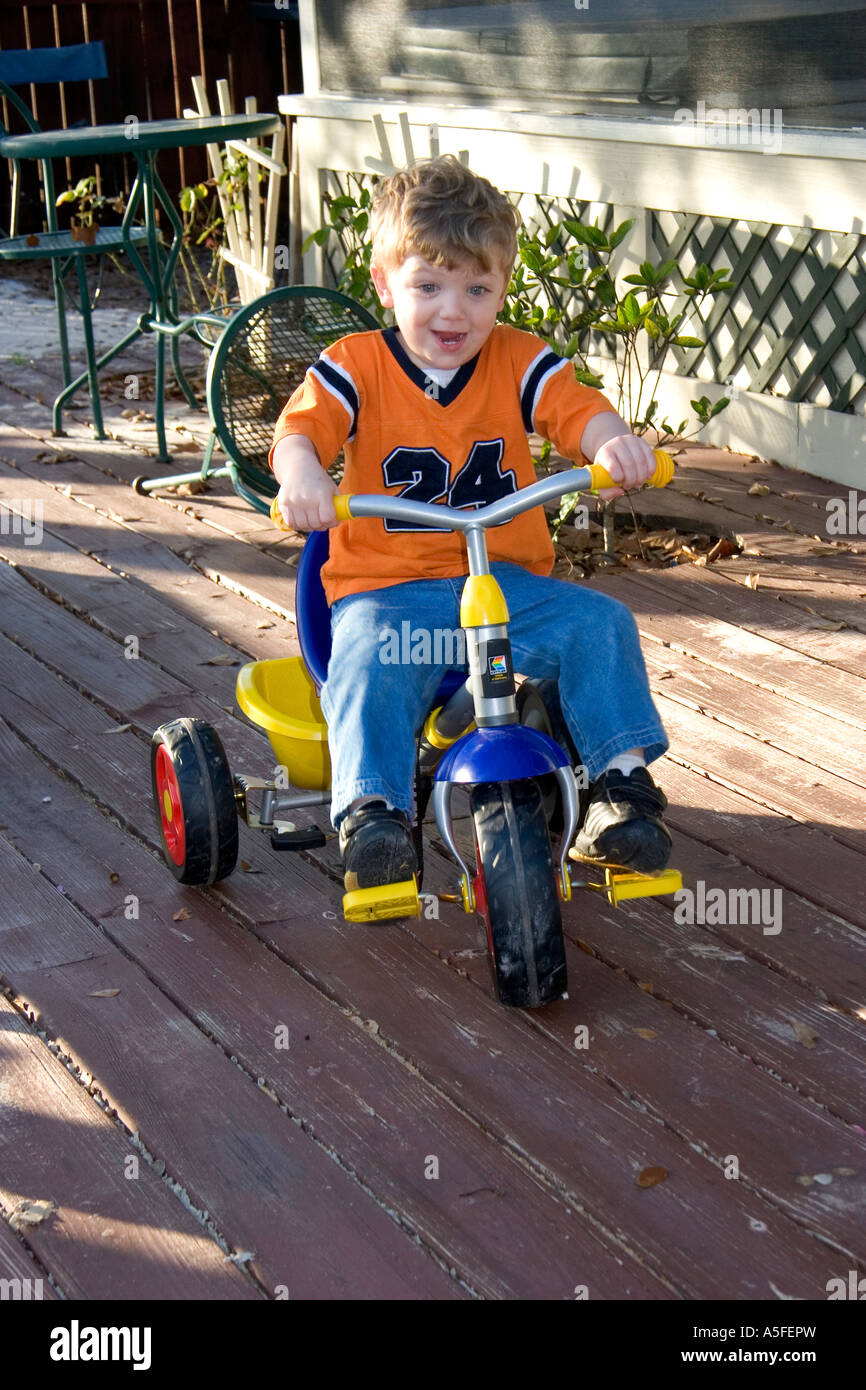 A three year old boy riding a tricycle in Florida Stock Photo Alamy